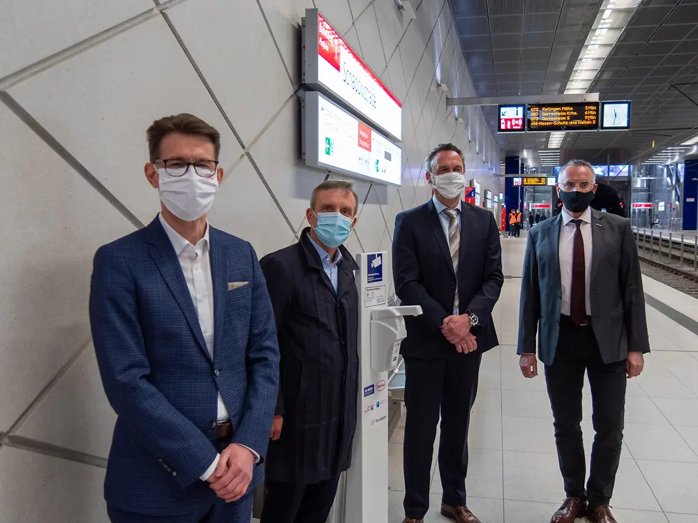 Henkel-Standortleiter Dr. Daniel Kleine, Oberbürgermeister Thomas Geisel, Leiter Standortlogistik BASF in Düsseldorf Dr. Uwe Hömmerich und Vorstandsvorsitzender der Rheinbahn Klaus Klar (vlnr.) bei der Installation eines Desinfektionsmittelspenders an einer U-Bahn Haltestelle der Rheinbahn.