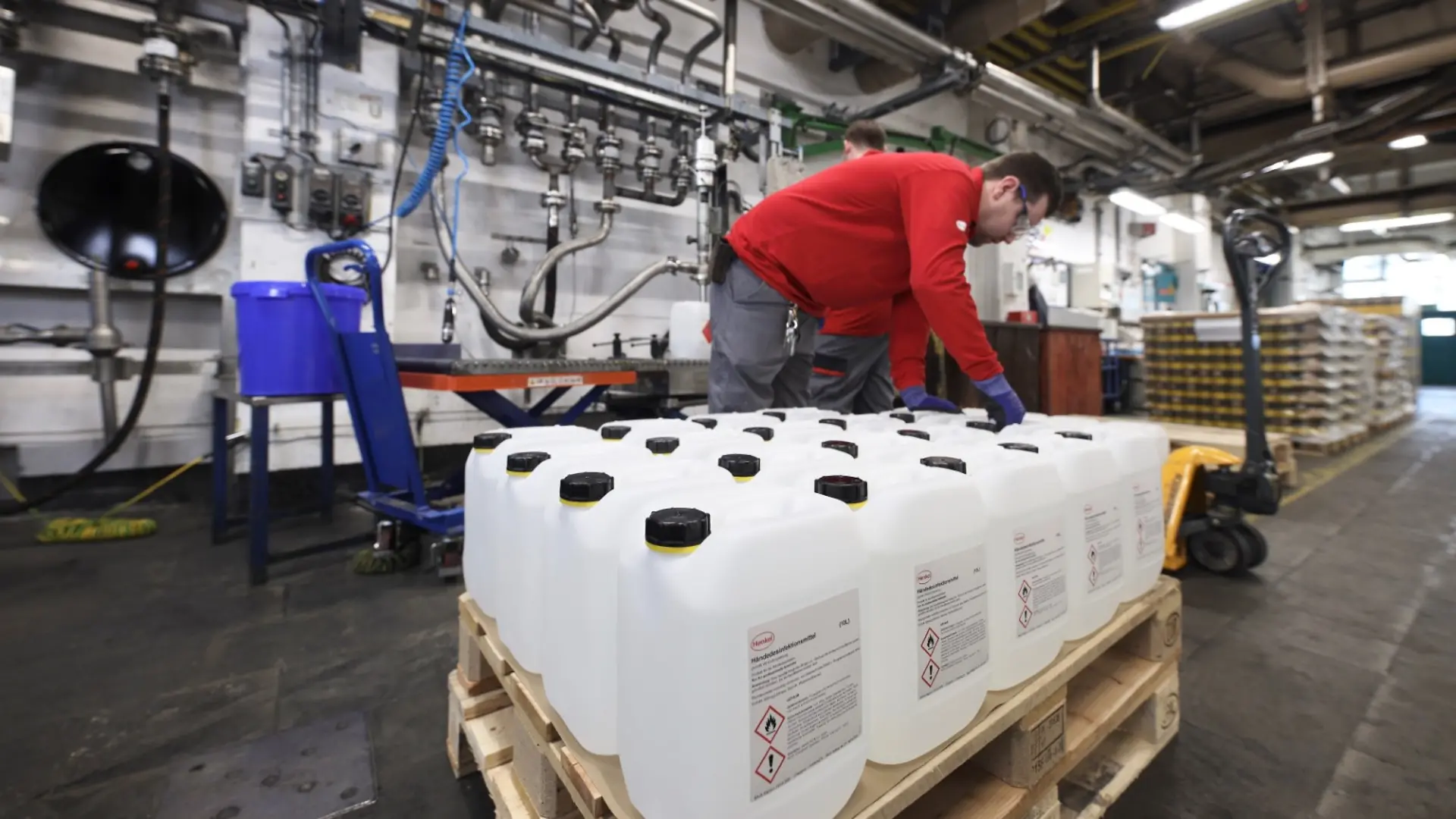 Henkel-Mitarbeiter packen Handdesinfektionsmittel in Düsseldorf ab.