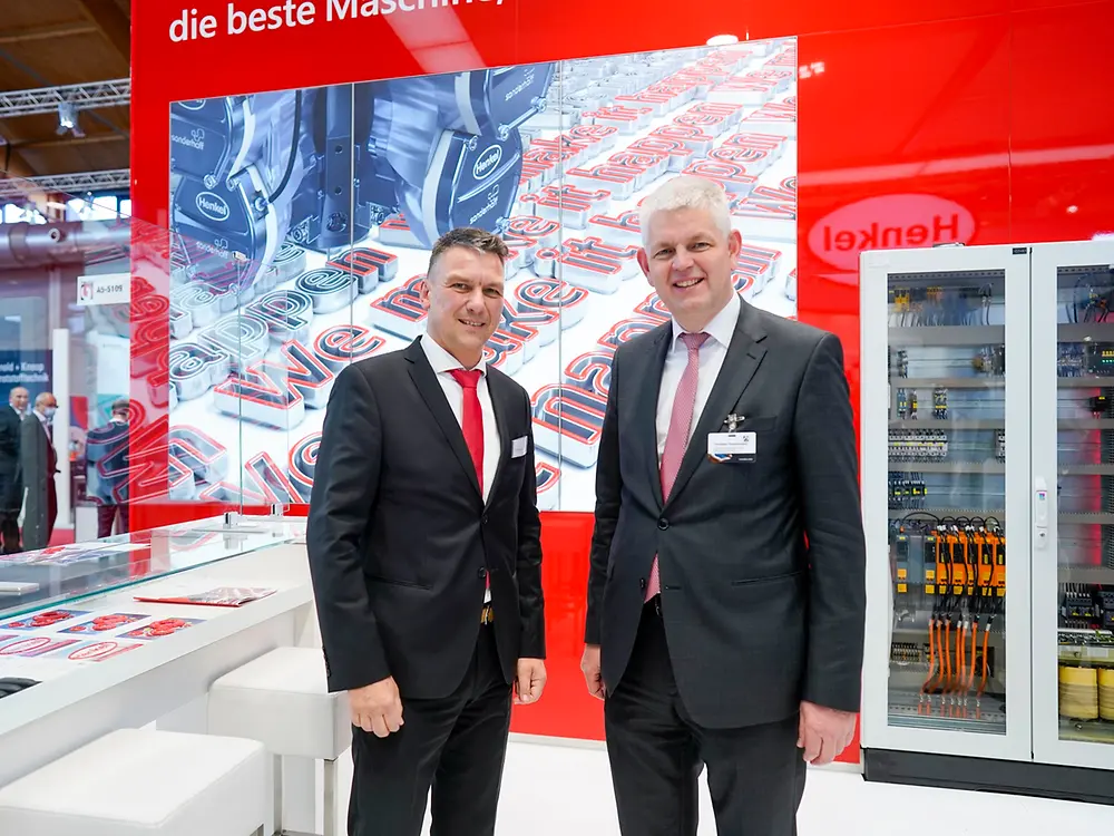 NRW-Staatssekretär Christoph Dammermann auf dem Henkel Stand der Fakuma im Gespräch