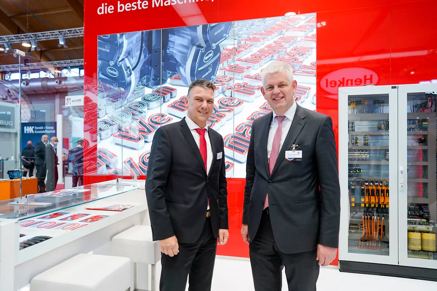 NRW-Staatssekretär Christoph Dammermann auf dem Henkel Stand der Fakuma im Gespräch