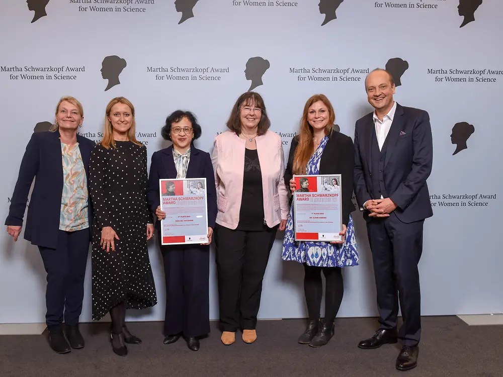 Vier Henkel-Vertreter:innen und die beiden Gewinnerinnen des Martha-Schwarzkopf-Preises stehen nebeneinander vor der Fotowand.