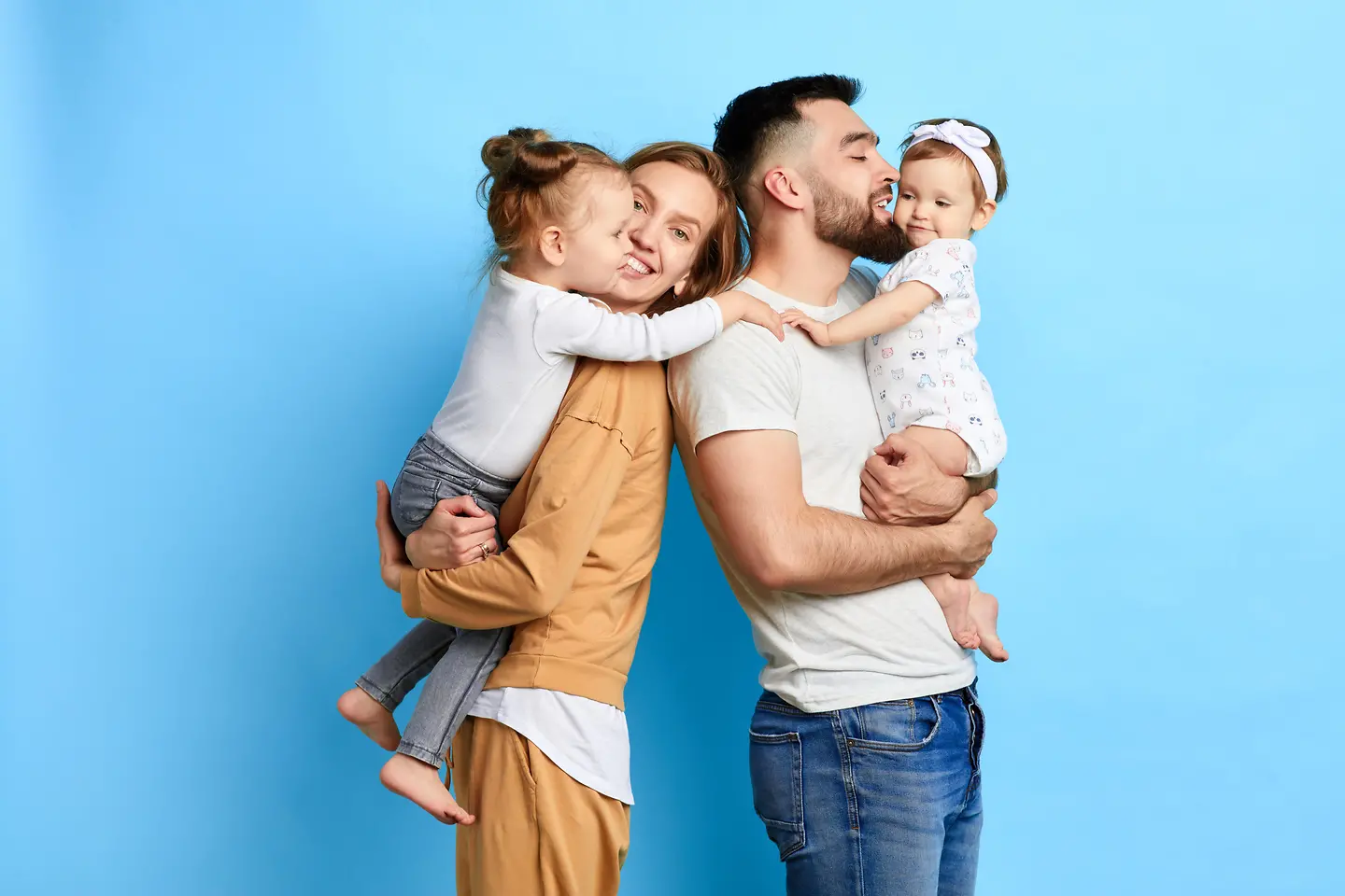 Eine Familie von 4 steht vor einem blauen Hintergrund.