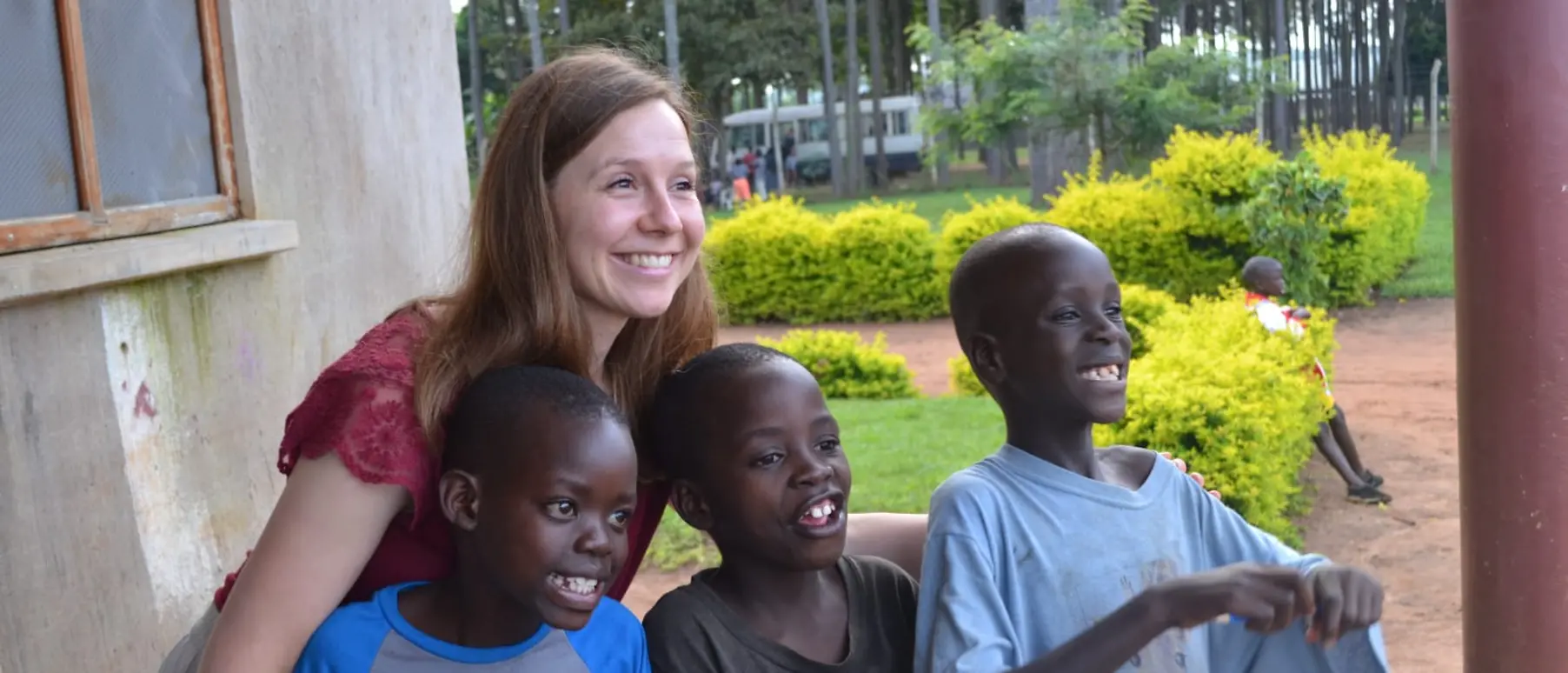 Henkel-Mitarbeiterin Monika Böhnke posiert mit drei Jungen der Sonrise Ministries für ein Foto.