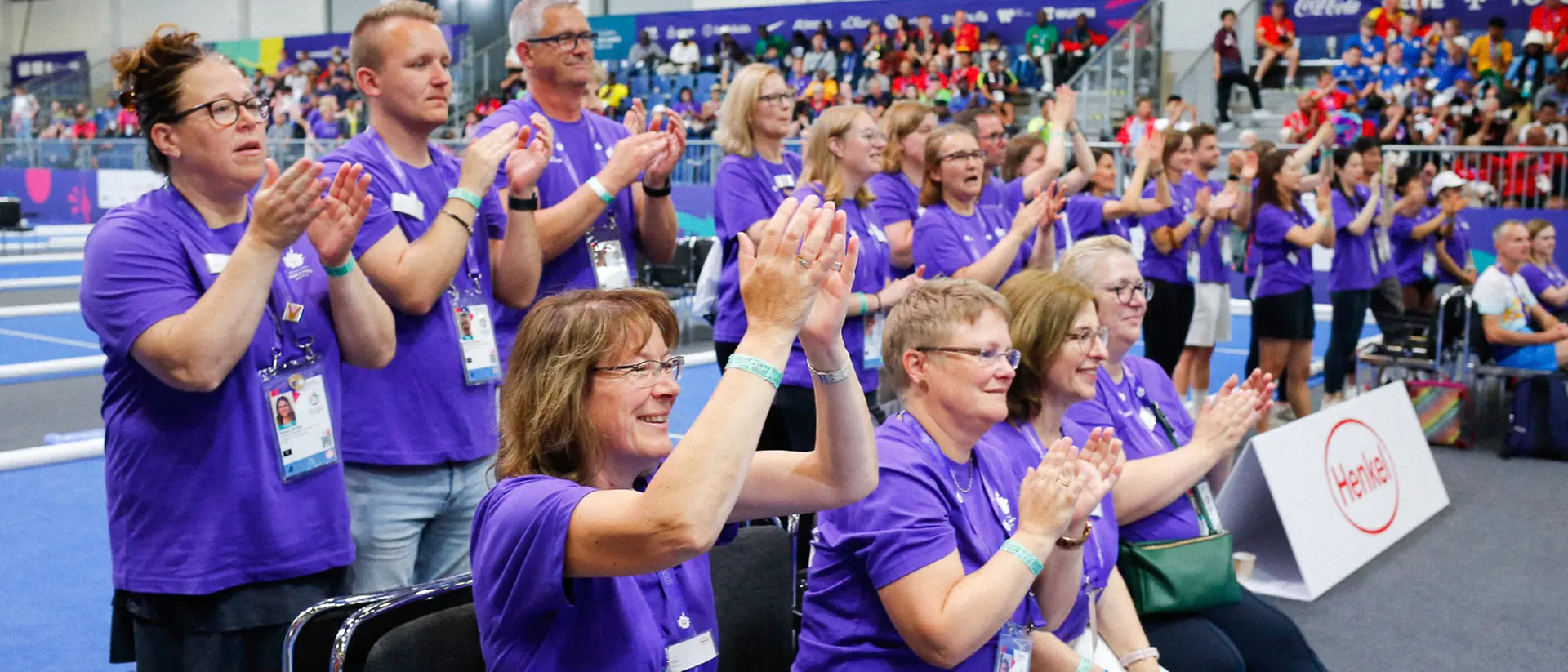 Eine Gruppe von ehrenamtlichen Helfern von Henkel feuert Athlet:innen bei den Special Olympics an.