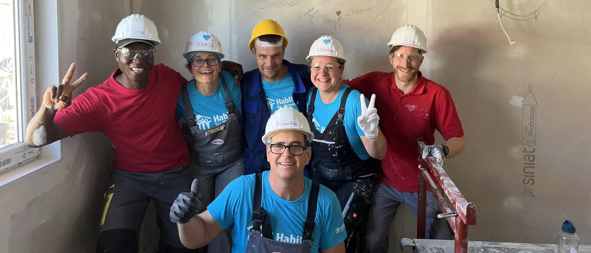 Eine Gruppe von ehrenamtlichen Helfern in Schutzkleidung posiert für ein Gruppenfoto.