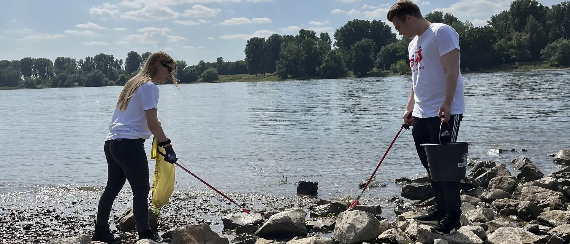 Trashfighters sammeln Müll an einem Flußufer